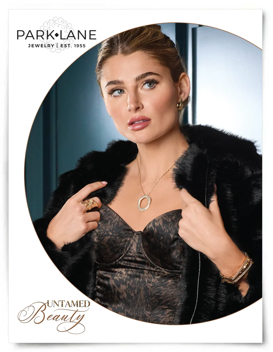 Model wearing a blue dress with a large necklace piece, heart ring and golden bracelet